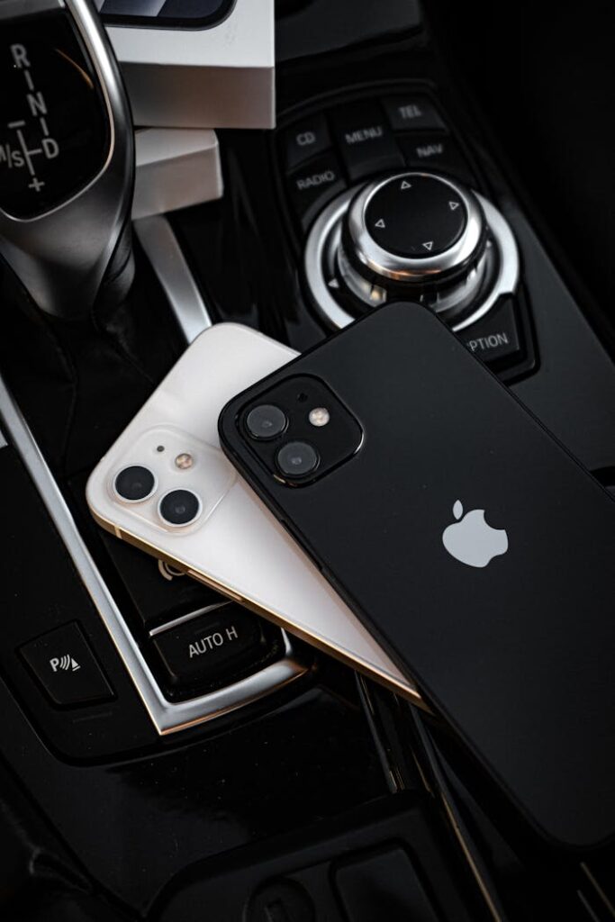 Two sleek smartphones placed on an elegant car gear console, showcasing technology and luxury.